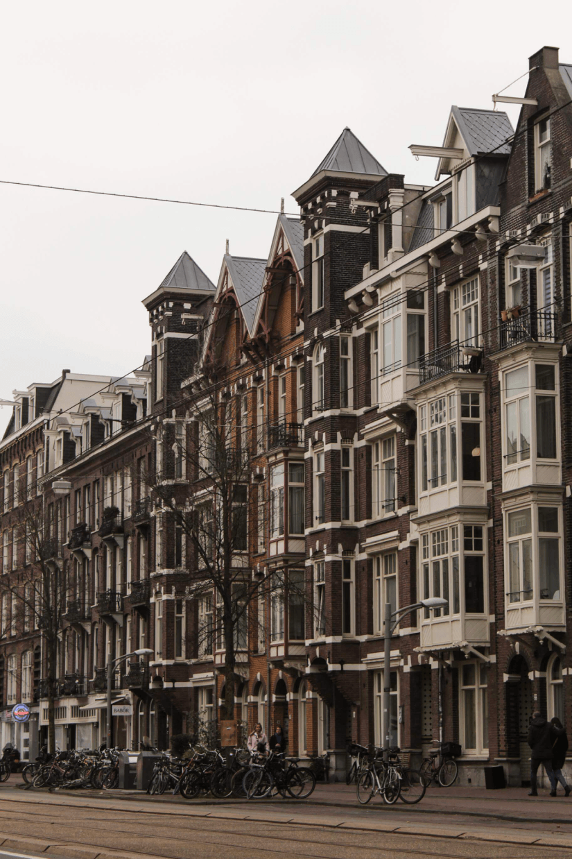 Historische Amsterdamse grachtenpanden met fietsen op straat – stedelijk straatbeeld vastgoedinvesteringen Chronos Investments B.V.